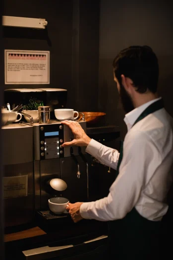waiter-making-cup-coffee-from-espresso-machine